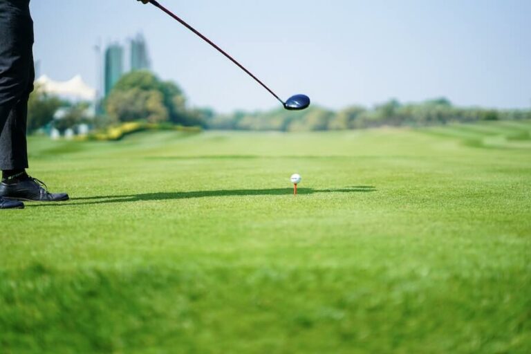 golf player preparing to hit golf ball with driver