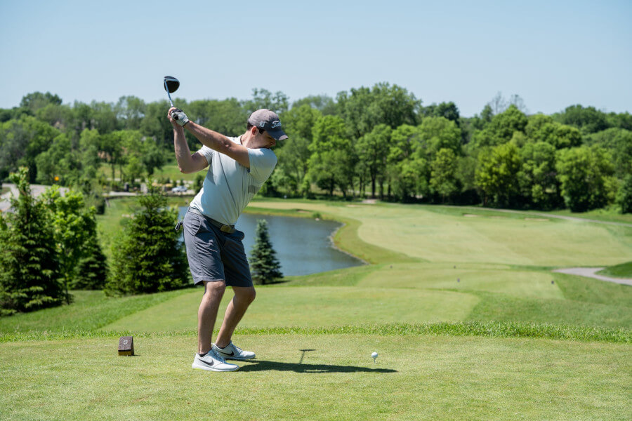 golfer holding golf club at top of the backswing position
